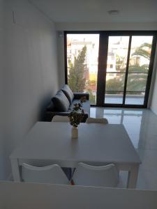 una mesa blanca y sillas en una sala de estar con sofá en Zona Güemes departamento nuevo en Mar del Plata