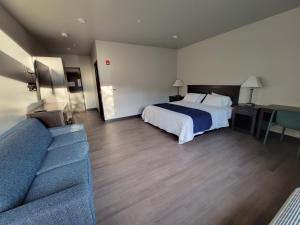 Habitación de hotel con cama y sofá en Watershed Hotel, en Sheboygan