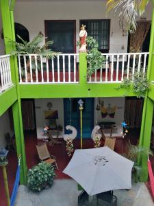 a balcony with a table and an umbrella at Hostel La Casona 1859 in Guaduas