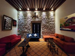 una sala de estar con sofás y una pared de piedra. en Casa monarca en Morelia