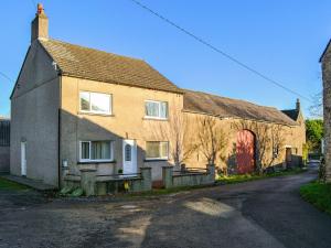 a large brick house on a street at The Farmhouse At Lane Foot in Tallentire