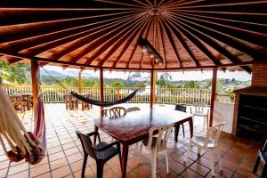 a porch with a table and chairs and a hammock at Finca-Hotel Montecarlo Guatape by Hope in Guatapé