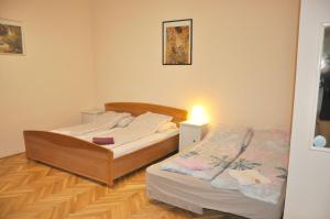 ブダペストにあるGaribaldi Apartmanのベッドルーム1室(ベッド2台付)、壁に照明が備わります。