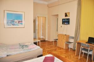 a room with a bed and a desk with a computer at Garibaldi Apartman in Budapest