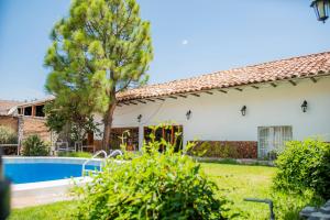 a house with a swimming pool and a tree at Llamita Hotel-Huancayo in Huancayo
