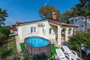 a house with a swimming pool in front of it at Villa Luck in Veleniki