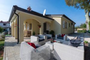 a patio with white chairs and a house at Villa Luck in Veleniki