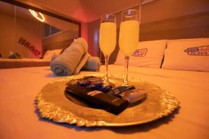 a plate with two champagne glasses on a bed at Motel ruta slavic in Punta Arenas