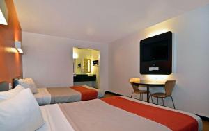 Habitación de hotel con 2 camas y mesa con TV. en Motel 6-Fairfield, CA - Napa Valley, en Fairfield