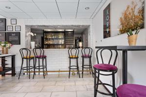 un bar con taburetes púrpura en un restaurante en Best Western Hotell Hudik, en Hudiksvall