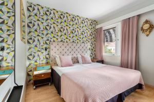 ein Schlafzimmer mit einem Bett und einer farbenfrohen Wand in der Unterkunft Best Western Hotell Hudik in Hudiksvall