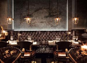 a dining room with tables and chairs and chandeliers at Stora Hotellet; BW Premier Collection in Umeå