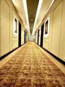 pusty korytarz z podłogą wyłożoną wykładziną w budynku w obiekcie Best Western Premier Hotel Gulberg Lahore w mieście Lahaur