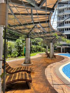 a patio with benches and a swimming pool at Luxury suite across SM Megamall in Manila