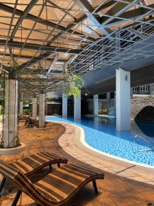- une grande piscine avec bancs dans un bâtiment dans l'établissement Luxury suite across SM Megamall, à Manille