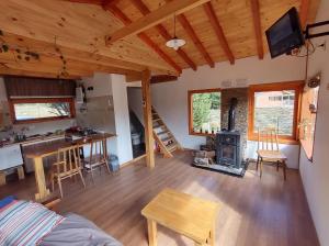 una sala de estar con estufa de leña en una cabaña en Casa de la ventana en Villa Meliquina