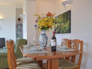 a table with a bottle of wine and a vase of flowers at Ty Glyndwr in Goodwick