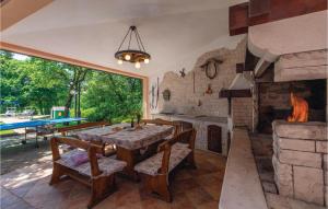 a dining room with a table and a fireplace at Stunning Home In Belavici With 3 Bedrooms, Wifi And Outdoor Swimming Pool in Hreljići
