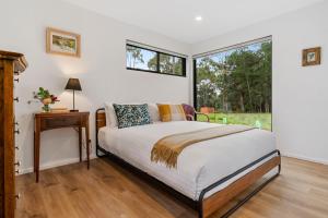 a bedroom with a bed and a window at The Hide On Cloudy in Lunawanna