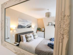 a mirror reflecting a bedroom with a bed at Red Robin Cottage in Chesterfield