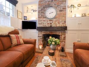 a living room with a brick fireplace with a clock at Kentish Knock in Deal