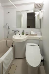 een badkamer met een toilet, een wastafel en een spiegel bij Hotel Reference Reisen in Fukuoka