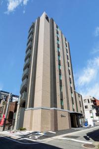 een hoog gebouw op de hoek van een straat bij Hotel Reference Reisen in Fukuoka