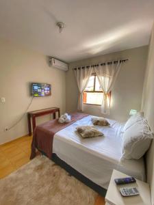 a bedroom with a large bed and a window at Casa aconchegante à 400m da Praia da Tartaruga - Ar condicionado - WIFI 450MB - Netflix - Cozinha Completa - Garagem in Rio das Ostras