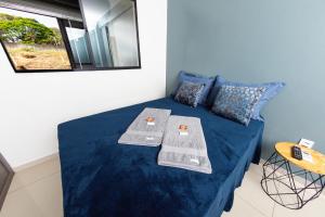 a room with a bed with blue sheets and a mirror at Jahu Center Plaza Flats in Jaú