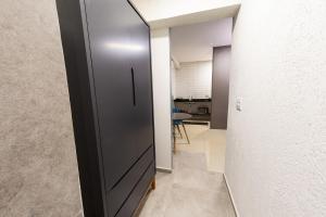 a hallway with a sliding door and a mirror at Jahu Center Plaza Flats in Jaú