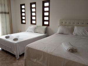 - deux lits assis l'un à côté de l'autre dans une pièce dans l'établissement Casa da Fê, à São Sebastião