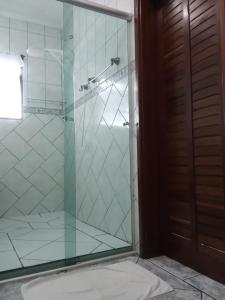 a glass shower with a glass door in a bathroom at Casa da Fê in São Sebastião