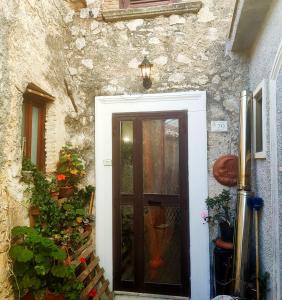 a door in a stone building with flowers and plants at La Casetta di Alice in Villalago