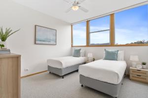 1 dormitorio con 2 camas y ventana en Blue Cottage Bruny Island en Alonnah