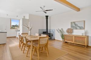 Blue Cottage Bruny Island في Alonnah: مطبخ وغرفة طعام مع طاولة وكراسي