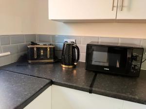 a microwave and a toaster on a kitchen counter at Cheerful 2-bedroom home with off street parking in Blackpool