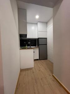een keuken met witte kasten en een houten vloer bij Deluxe Apartment In City Center in Tirana