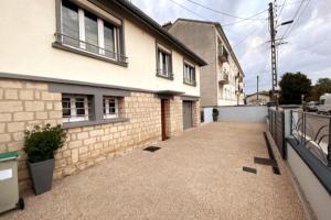 an empty driveway of a house with a fence at La Maison Sous Charmois in Verdun