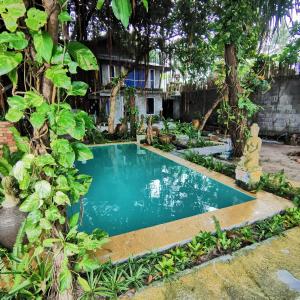 a swimming pool in a garden with trees at Anodash Homestay in Baan Tai