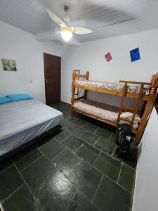 a bedroom with two bunk beds and a ceiling fan at recanto paraty mirim in Paraty
