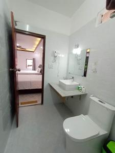 Un baño con inodoro, lavabo y cama. en Duang Champa 2 Guest house, en Luang Prabang