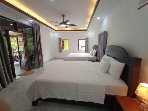 a bedroom with two beds and a ceiling fan at Duang Champa 2 Guest house in Luang Prabang