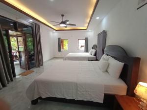 Un dormitorio con dos camas y un ventilador de techo. en Duang Champa 2 Guest house, en Luang Prabang