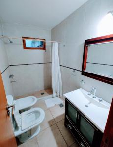 La salle de bains est pourvue de toilettes, d'un lavabo et d'un miroir. dans l'établissement Infinity lounge apartment, lujoso, céntrico y amplio, à San Rafael