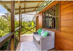 a porch with a couch on a balcony at Casa Osa Lion in Puerto Jiménez