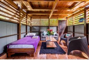 a bedroom with a bed and a couch and a table at Casa Osa Lion in Puerto Jiménez