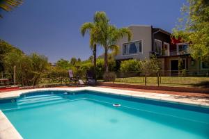 una gran piscina azul frente a una casa en Chalet Maru en La Falda