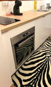 a zebra print rug in a kitchen with a oven at T2 avec parking - entièrement climatisé - Chez Élo in Schœlcher