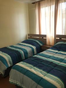 - 2 lits installés l'un à côté de l'autre dans une chambre dans l'établissement Casa a 5 min de Avda del Mar, à La Serena