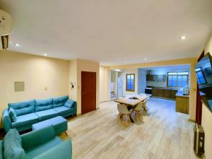 - un salon avec un canapé bleu et une table dans l'établissement La Terraza Apartment: lujoso, amplio y ubicado en microcentro., à San Rafael
